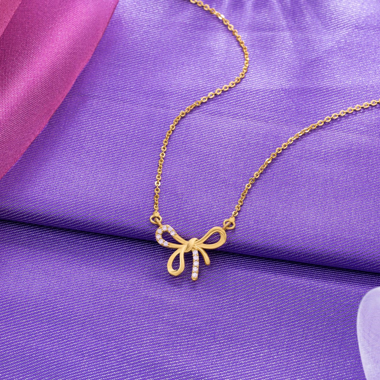 golden necklace with a bow and a diamond