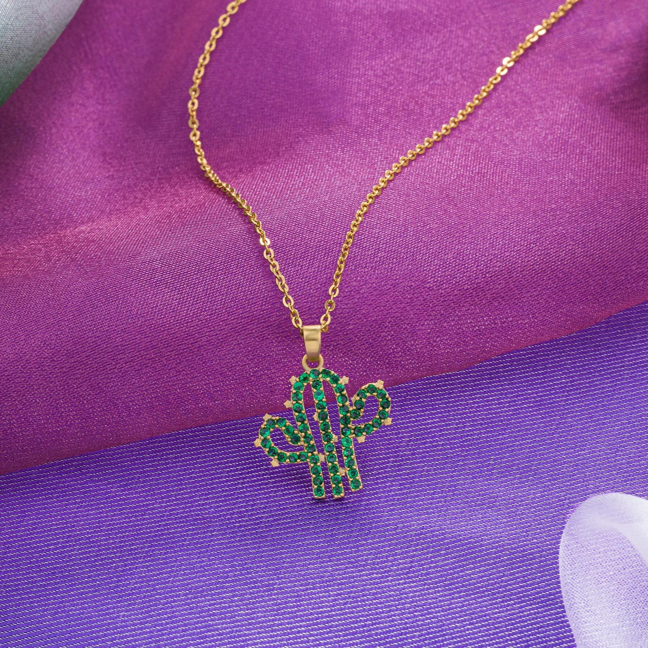 necklace with a cactus charm on it