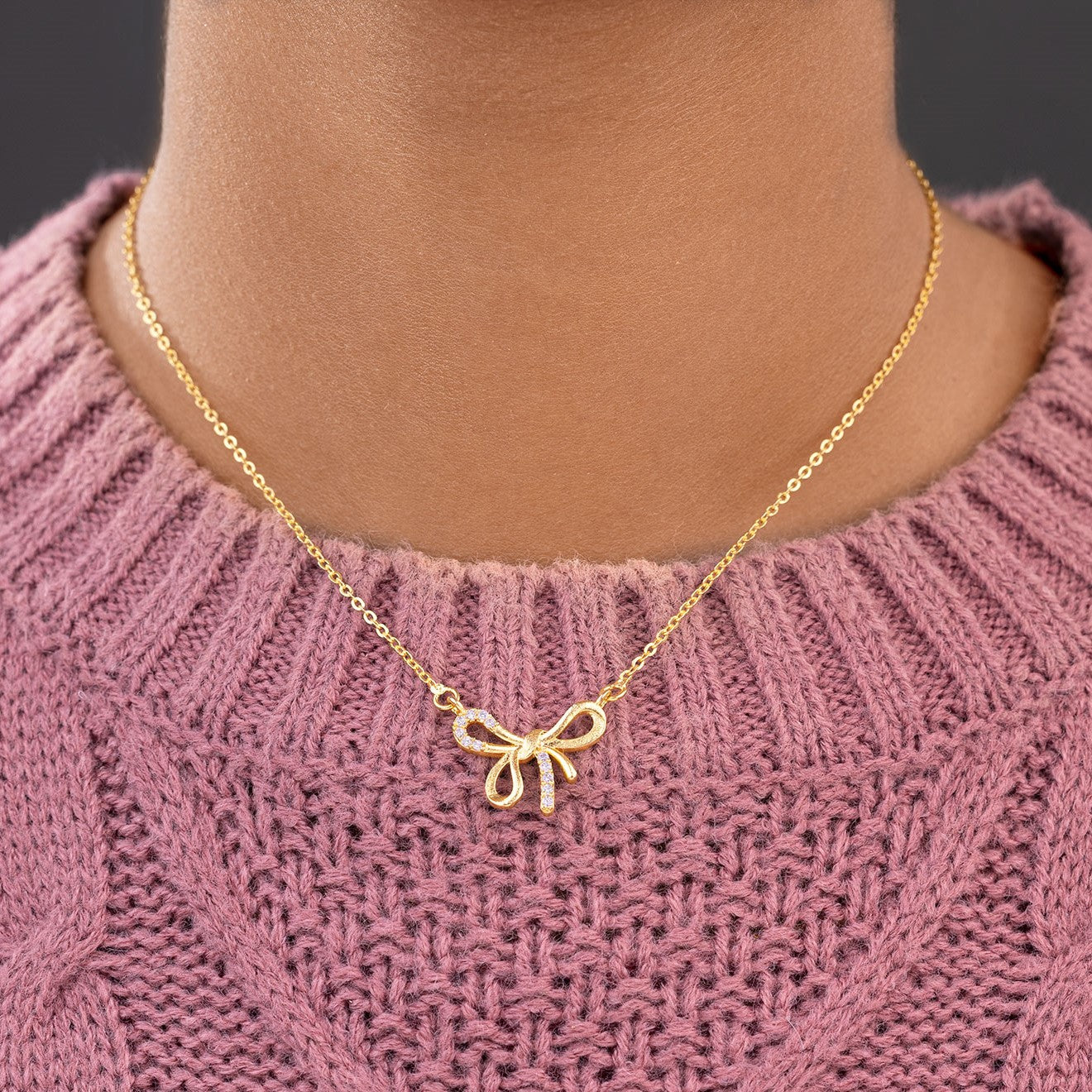 golden necklace with a bow and a diamond