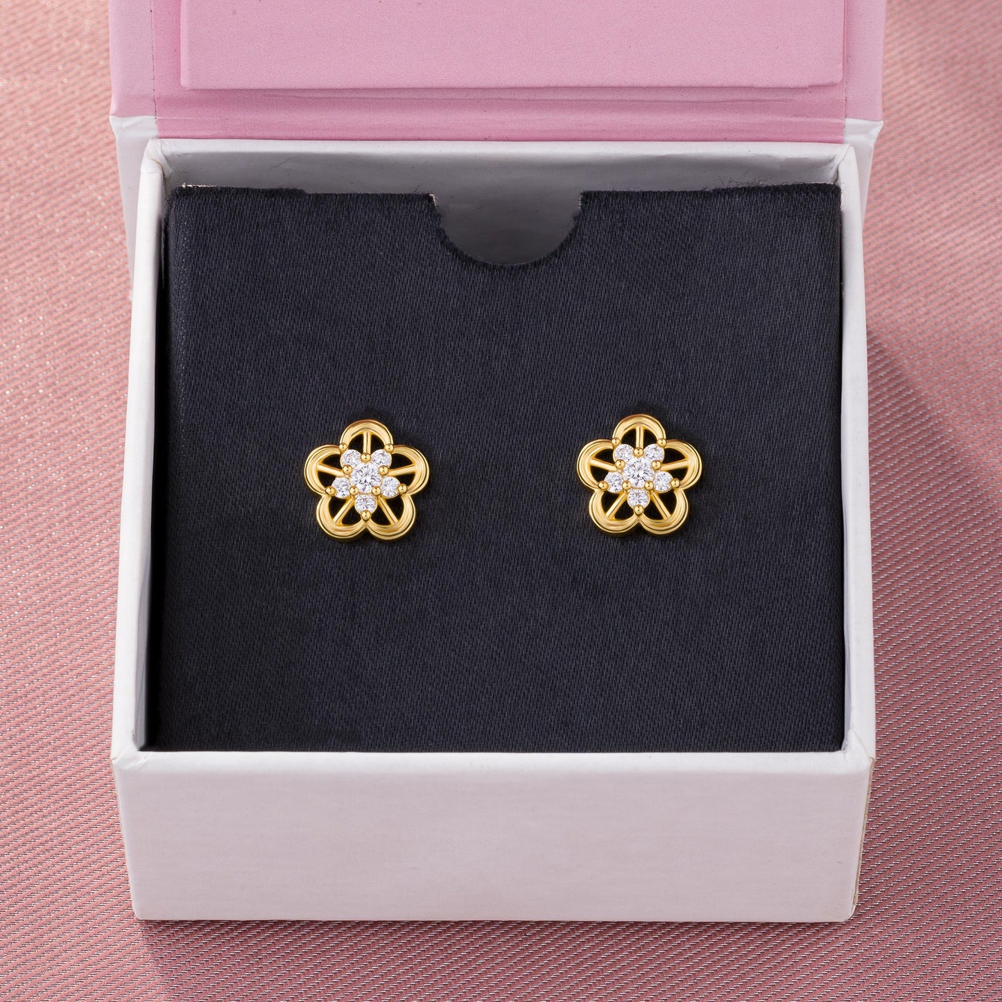 pair of golden earrings with a flower design