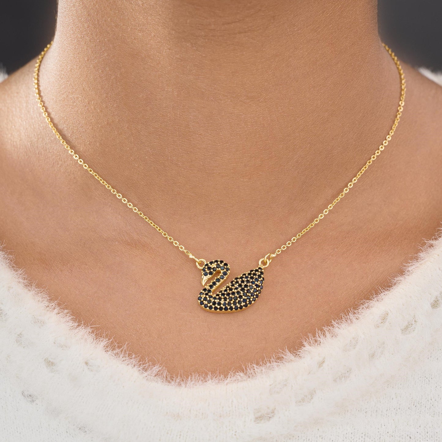 golden necklace with a stone swan