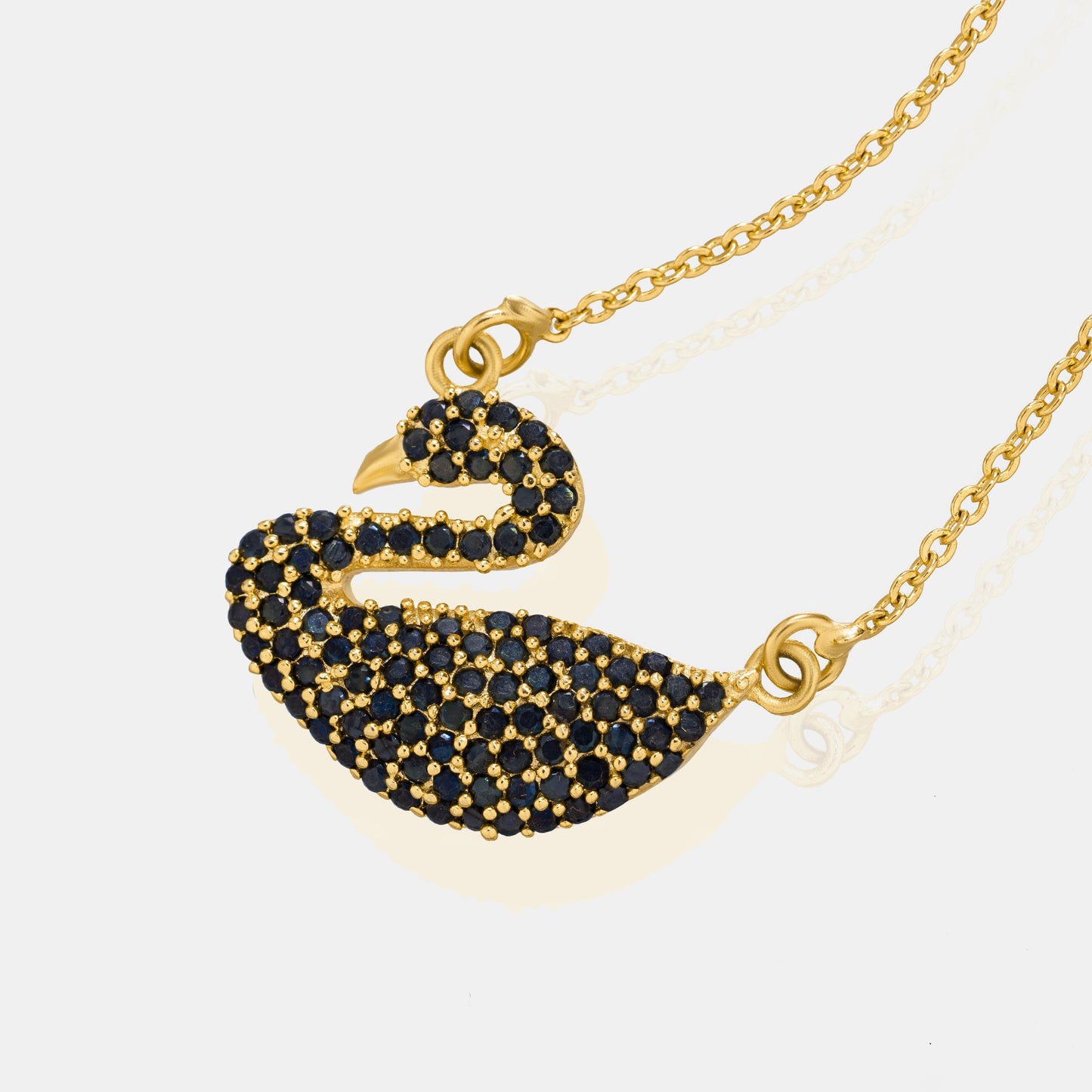 golden necklace with a stone swan