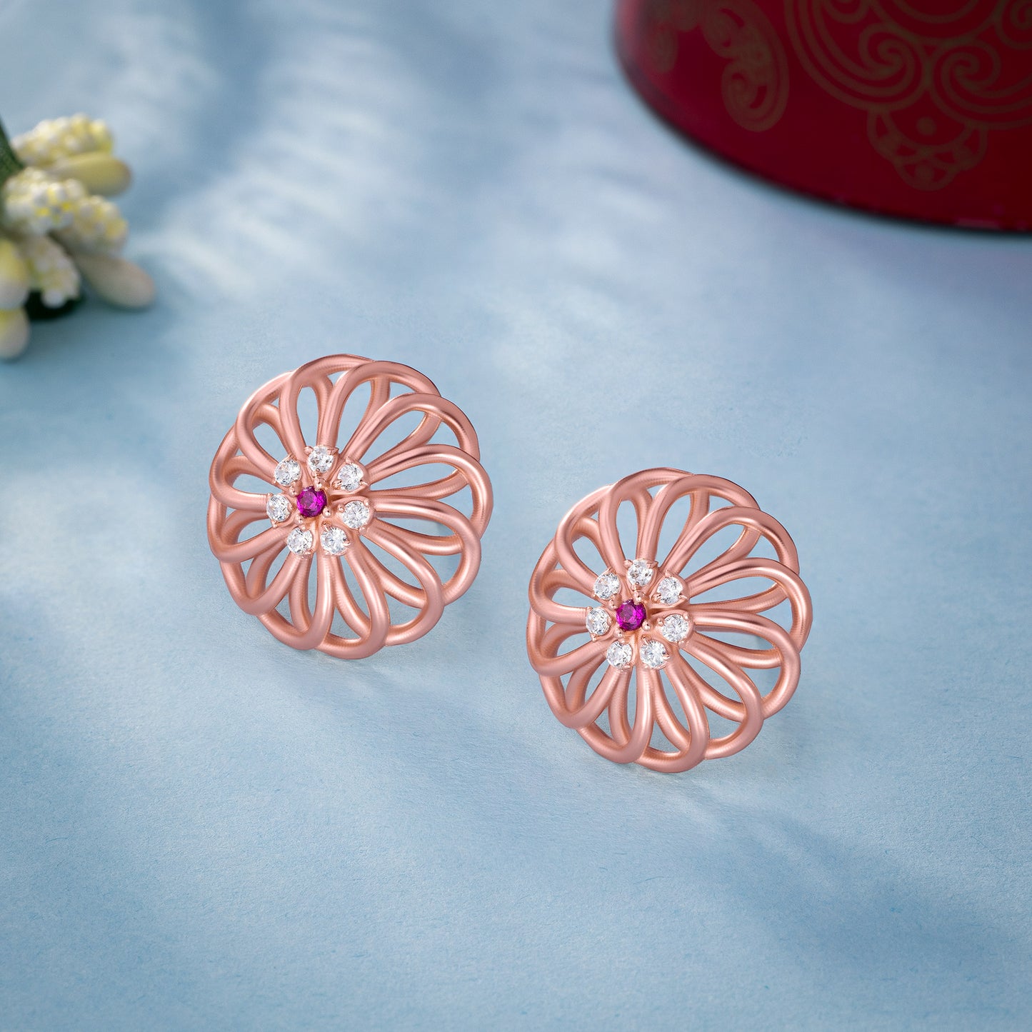 pair of rose gold earrings with diamonds and ruby