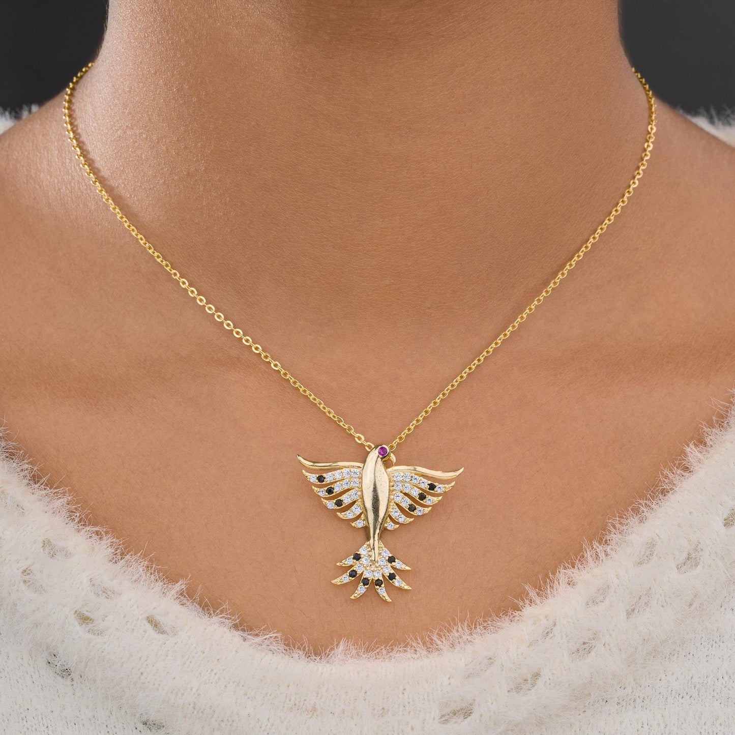 golden necklace with a bird on it