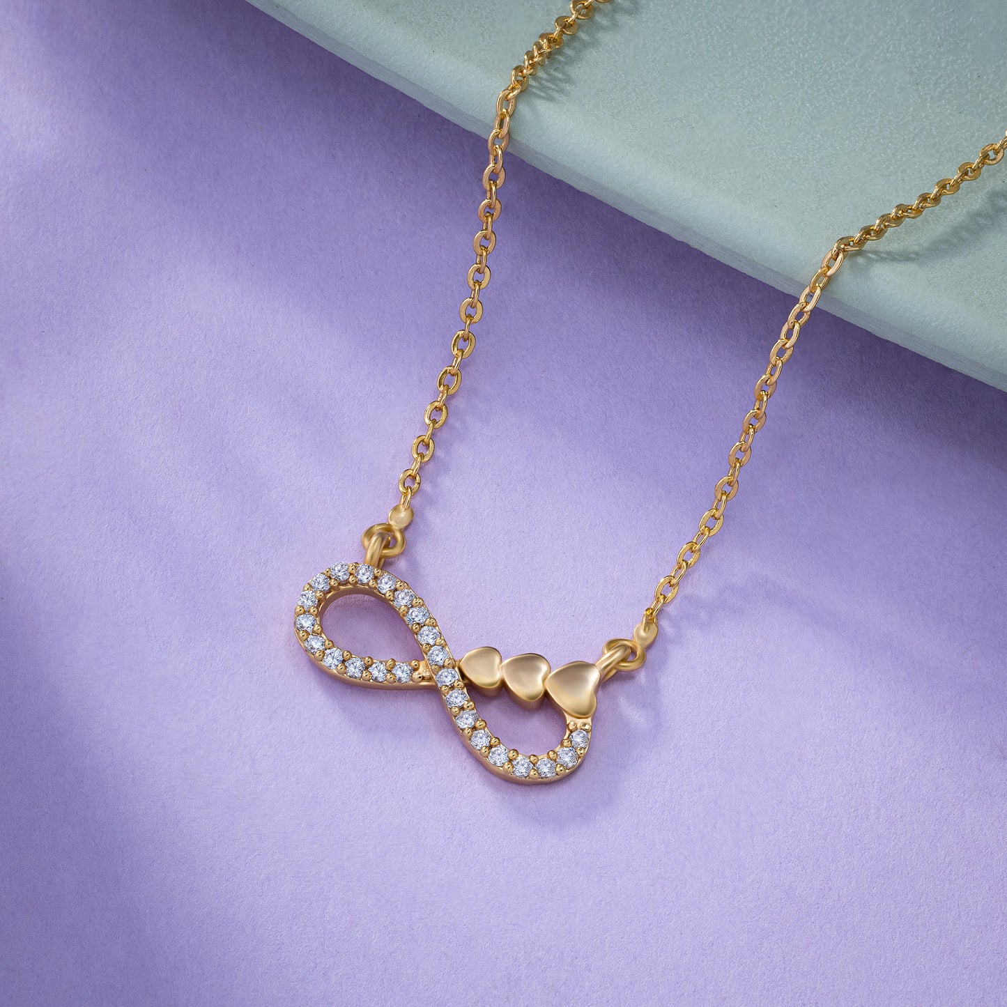 shine bright with this stunning golden necklace featuring a white infinity