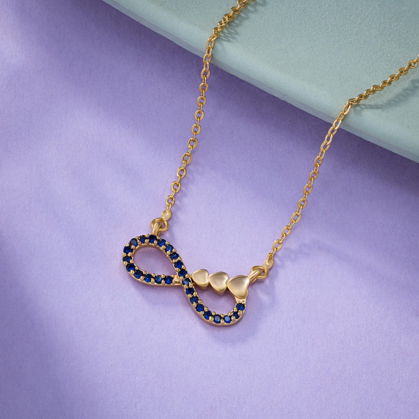 shine bright with this stunning golden necklace featuring a blue infinity