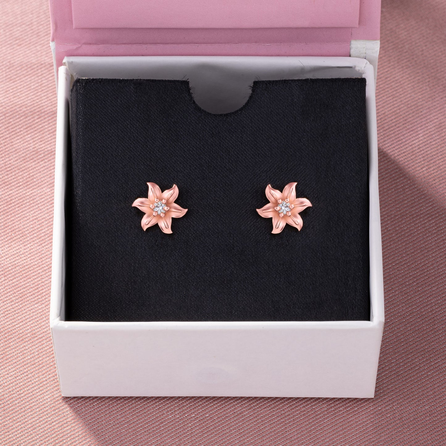 pair of rose gold earrings with white stones