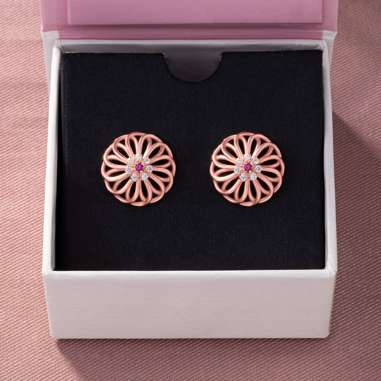 pair of rose gold earrings with diamonds and ruby