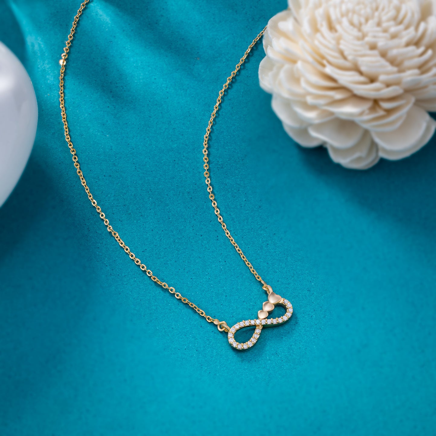 shine bright with this stunning golden necklace featuring a white infinity