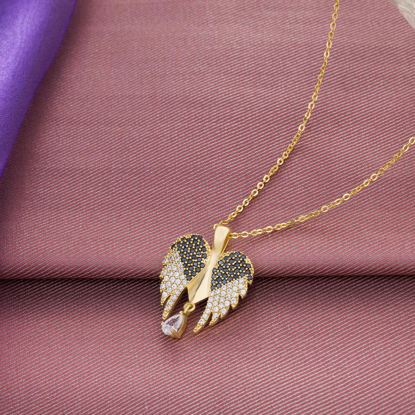 golden necklace with a diamond angel wing pendant