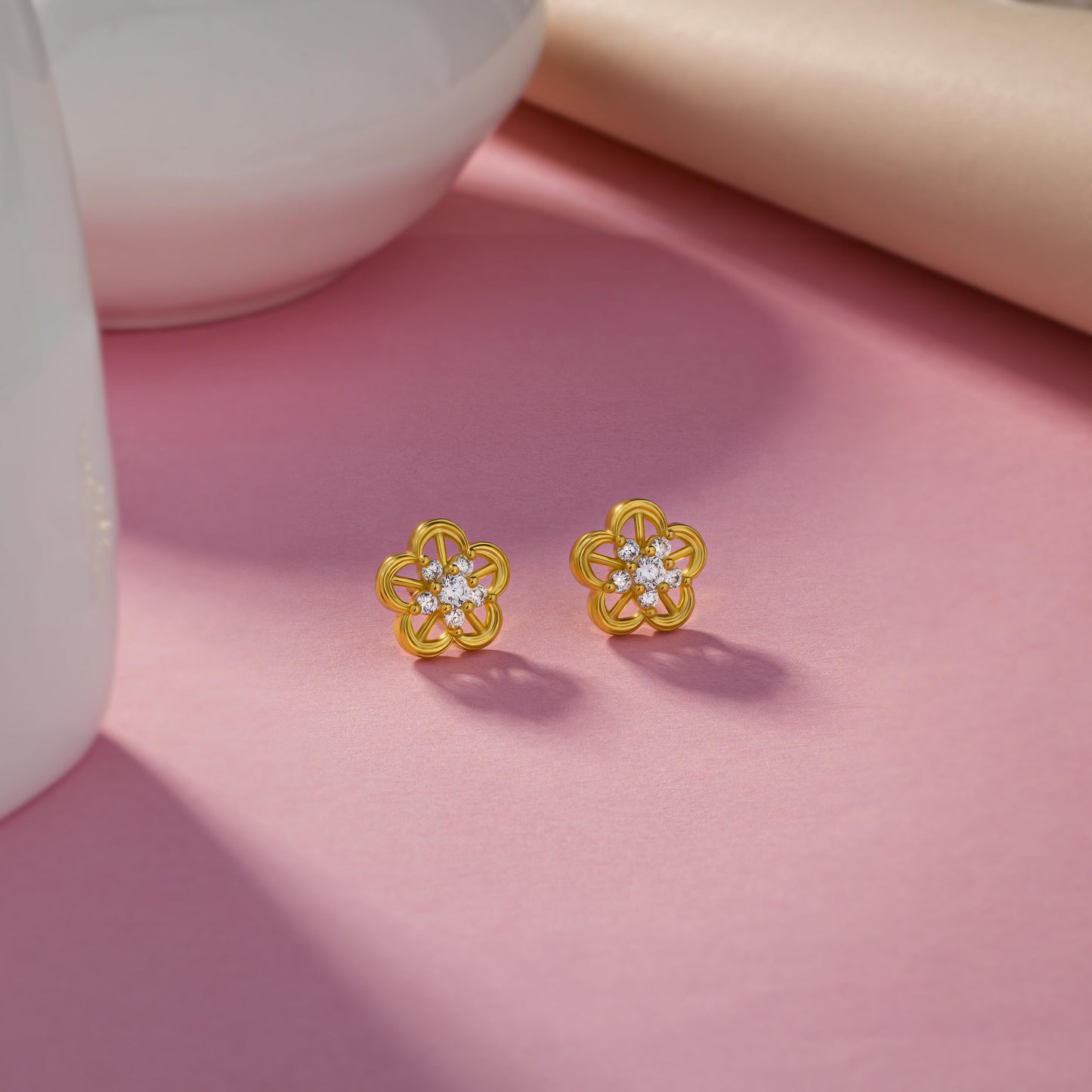 pair of golden earrings with a flower design