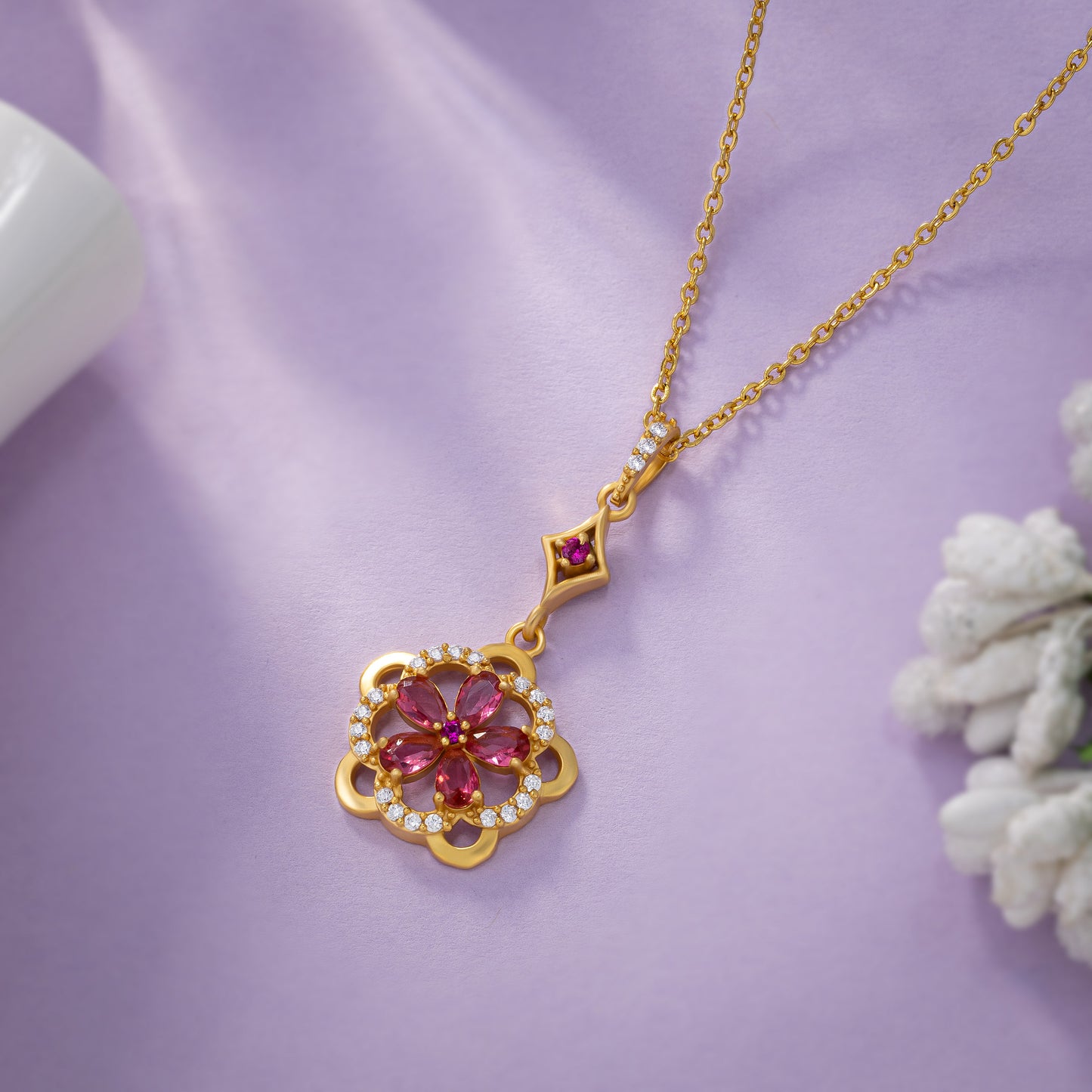 golden necklace adorned with a striking red flower pendant