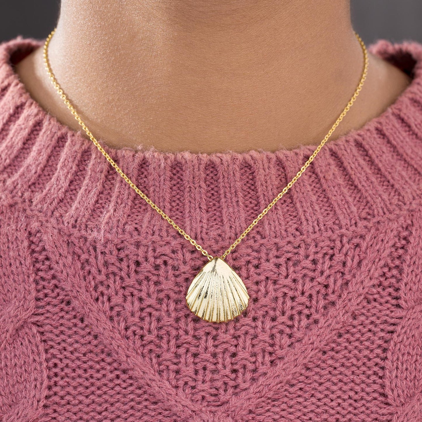 golden necklace with a shell on it