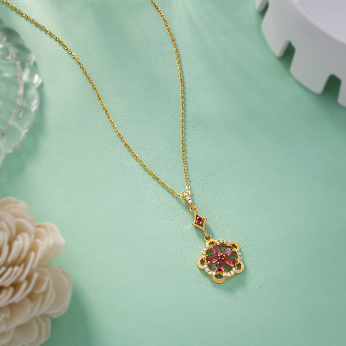 golden necklace adorned with a striking red flower pendant