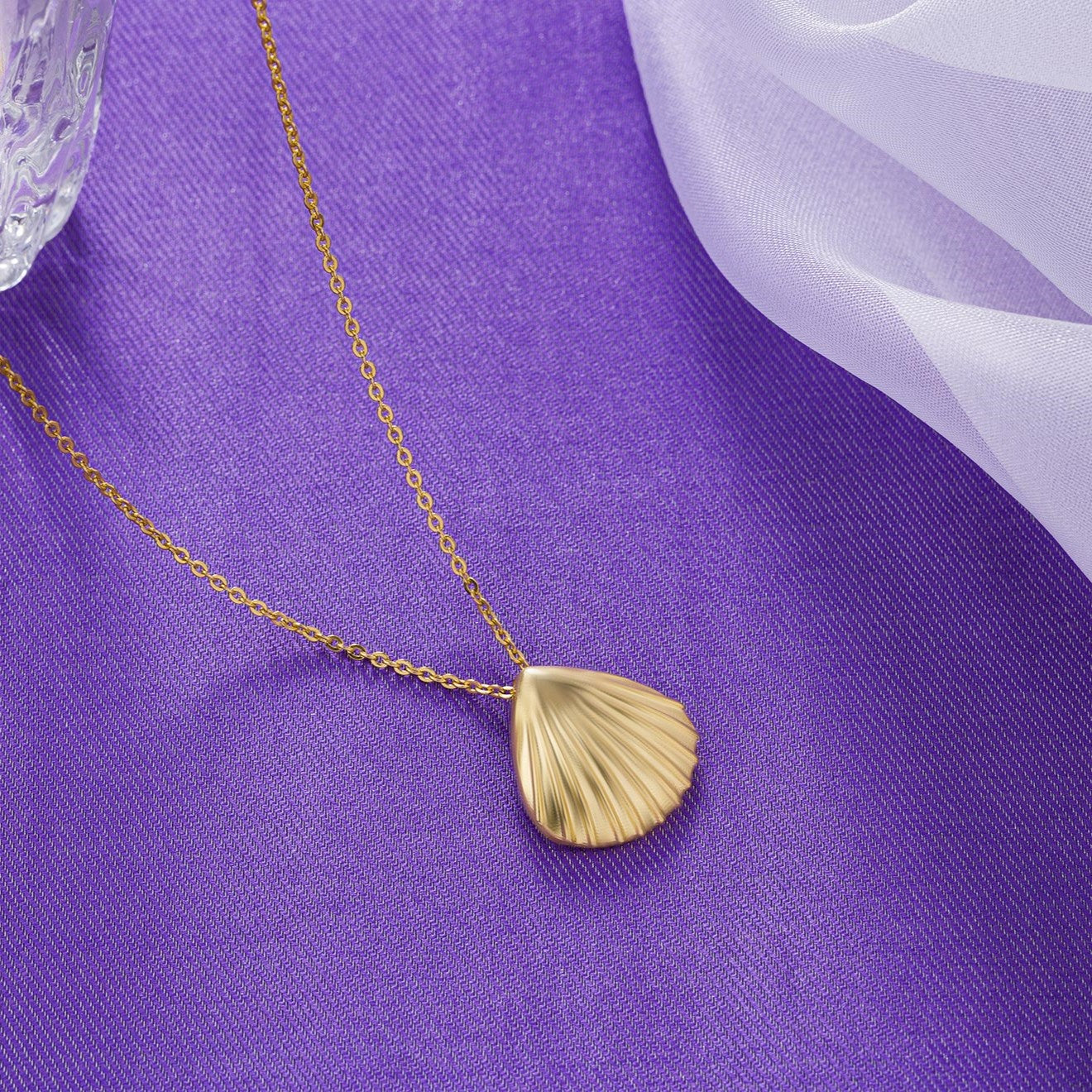 golden necklace with a shell on it