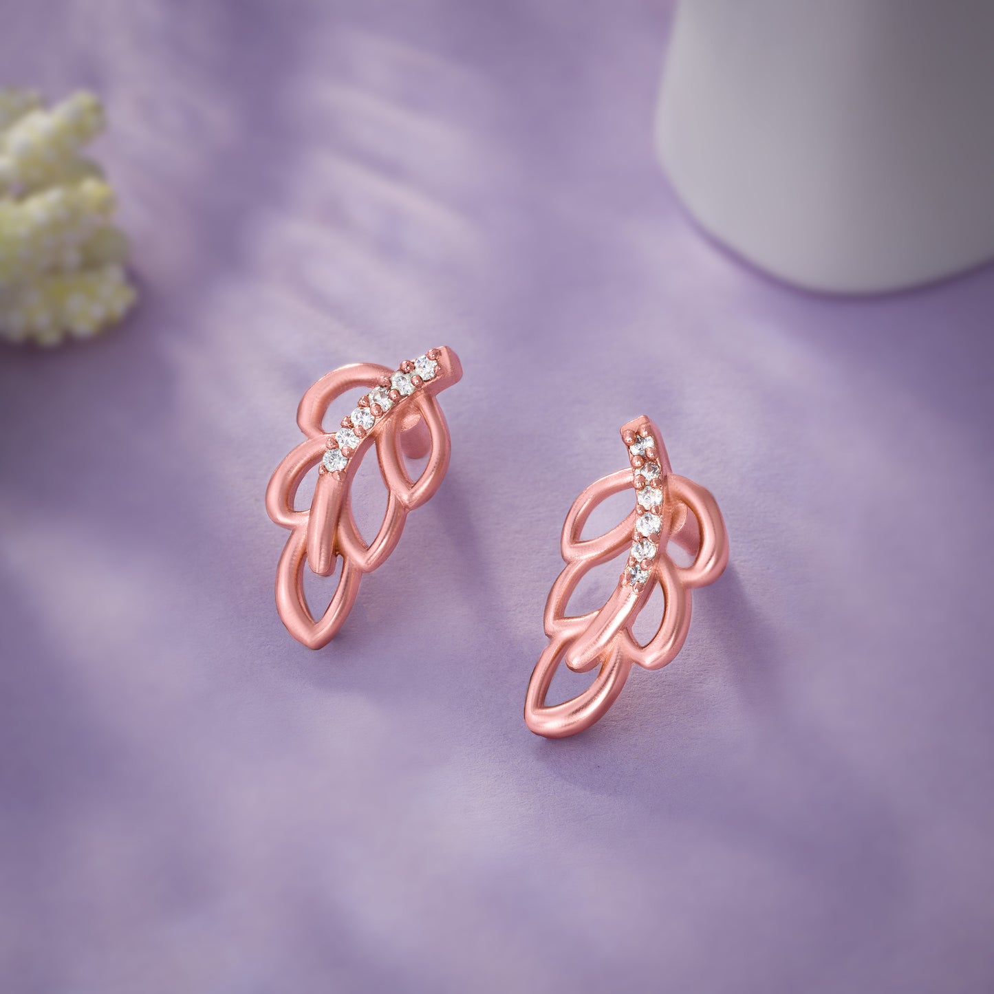 pair of rose gold earrings with a single diamond