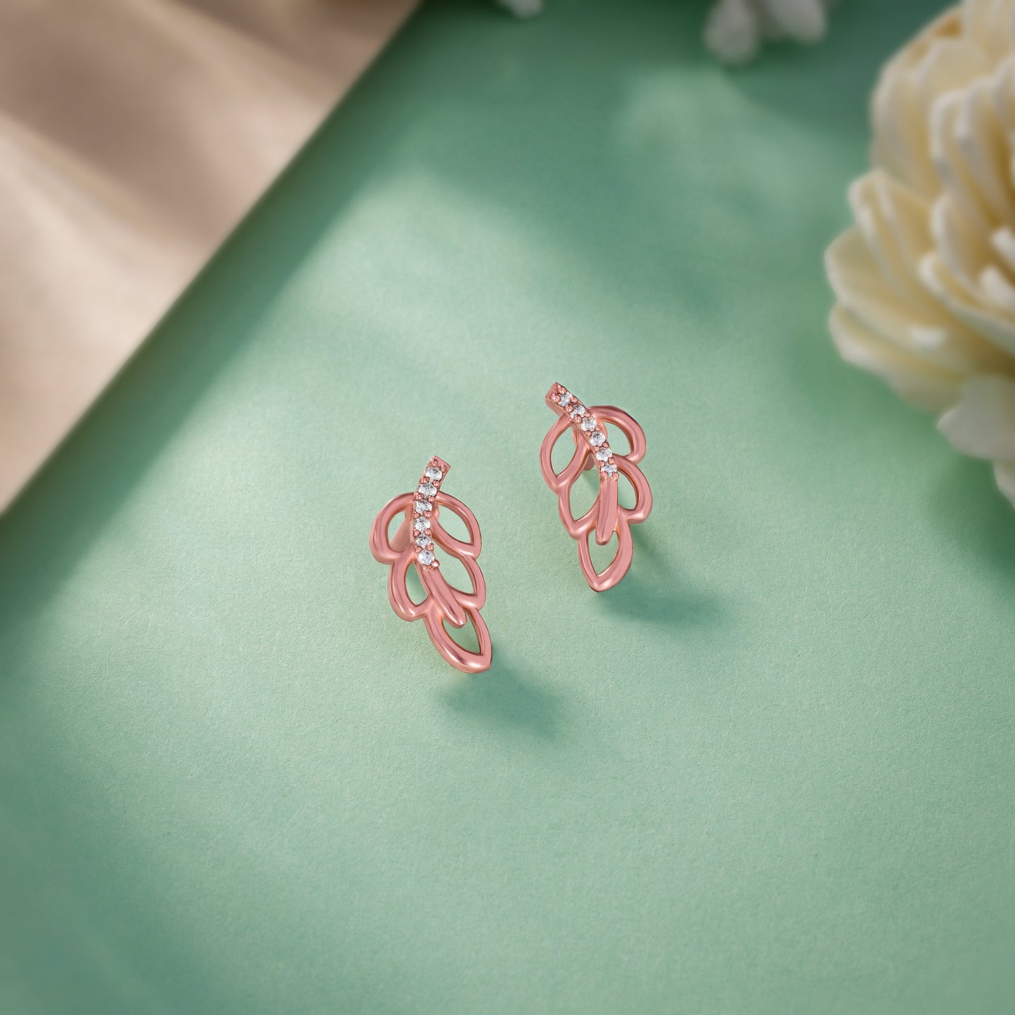 pair of rose gold earrings with a single diamond