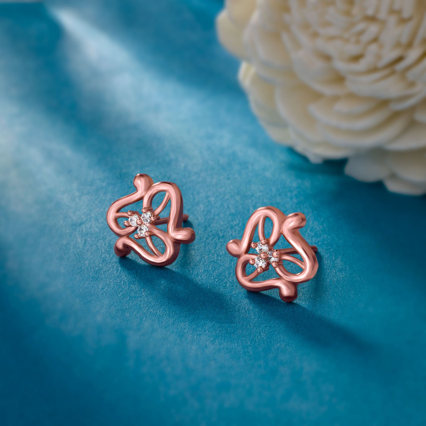 pair of rose gold earrings with white stones