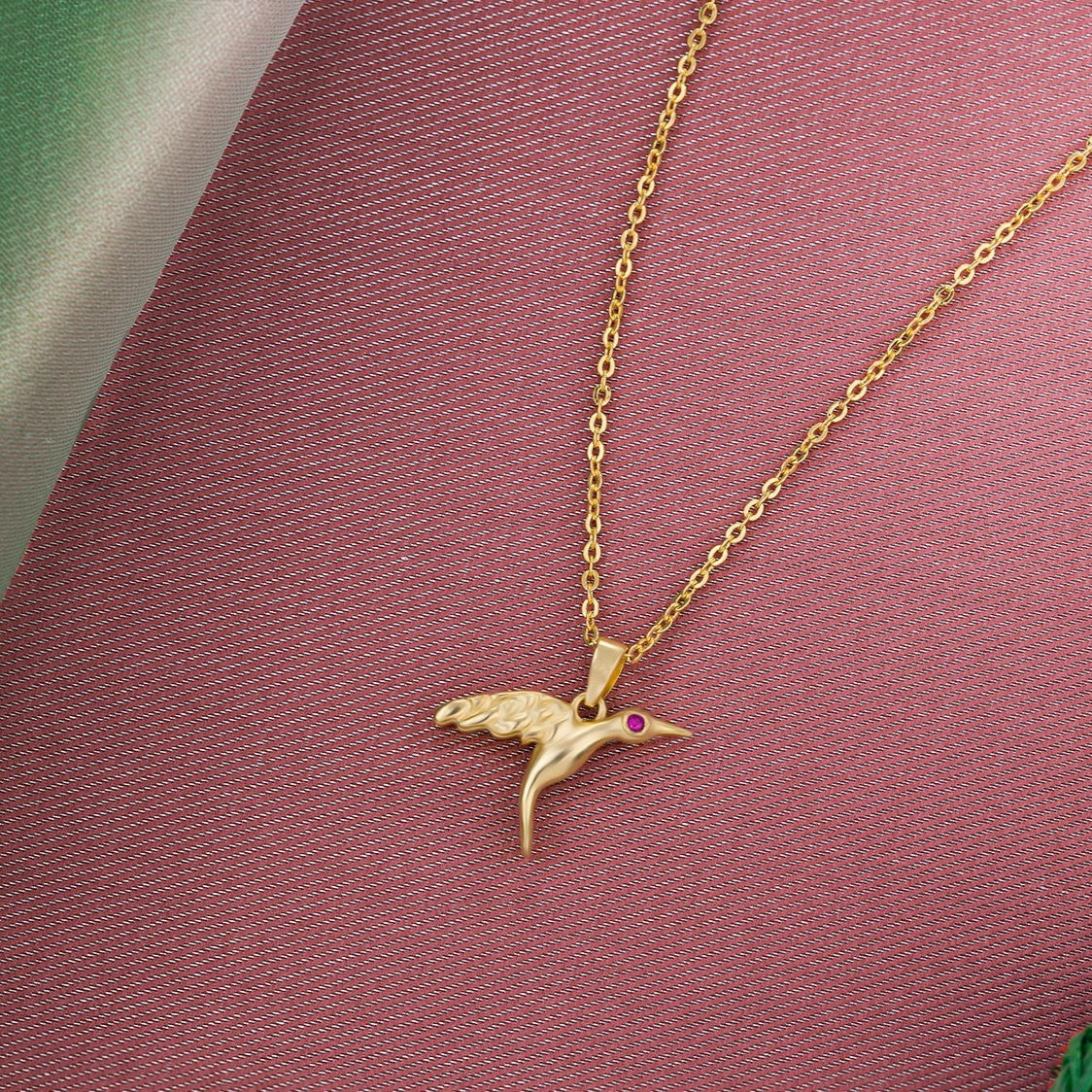 golden bird necklace with a diamond on the front