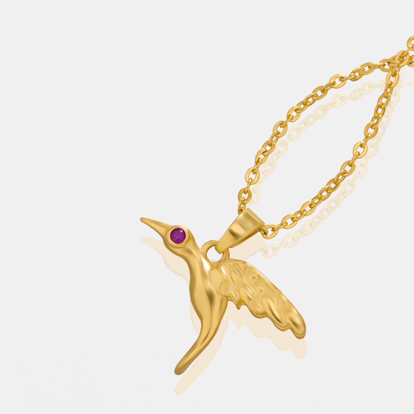 golden bird necklace with a diamond on the front