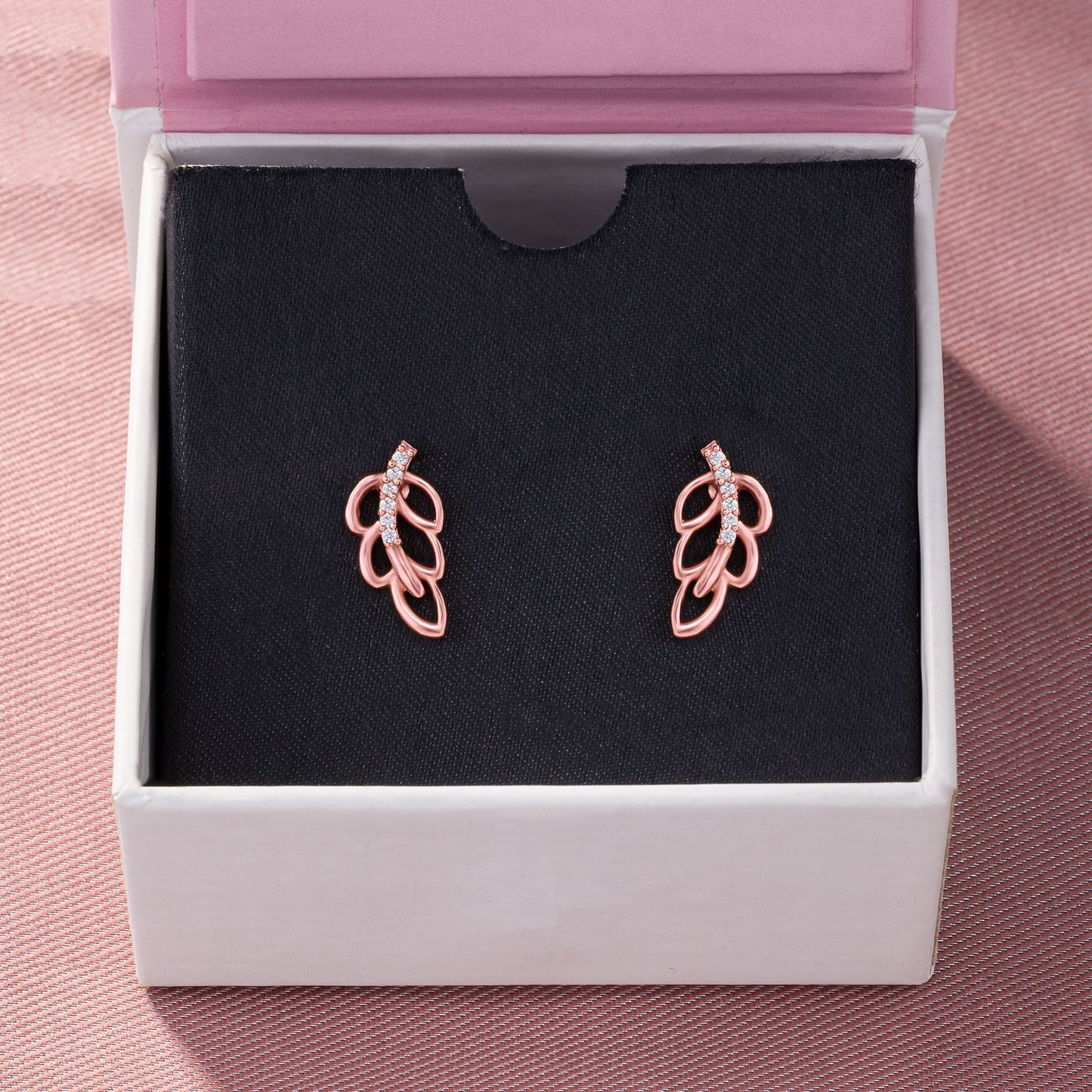 pair of rose gold earrings with a single diamond