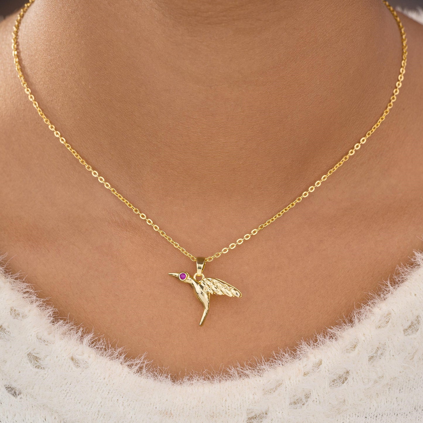 golden bird necklace with a diamond on the front