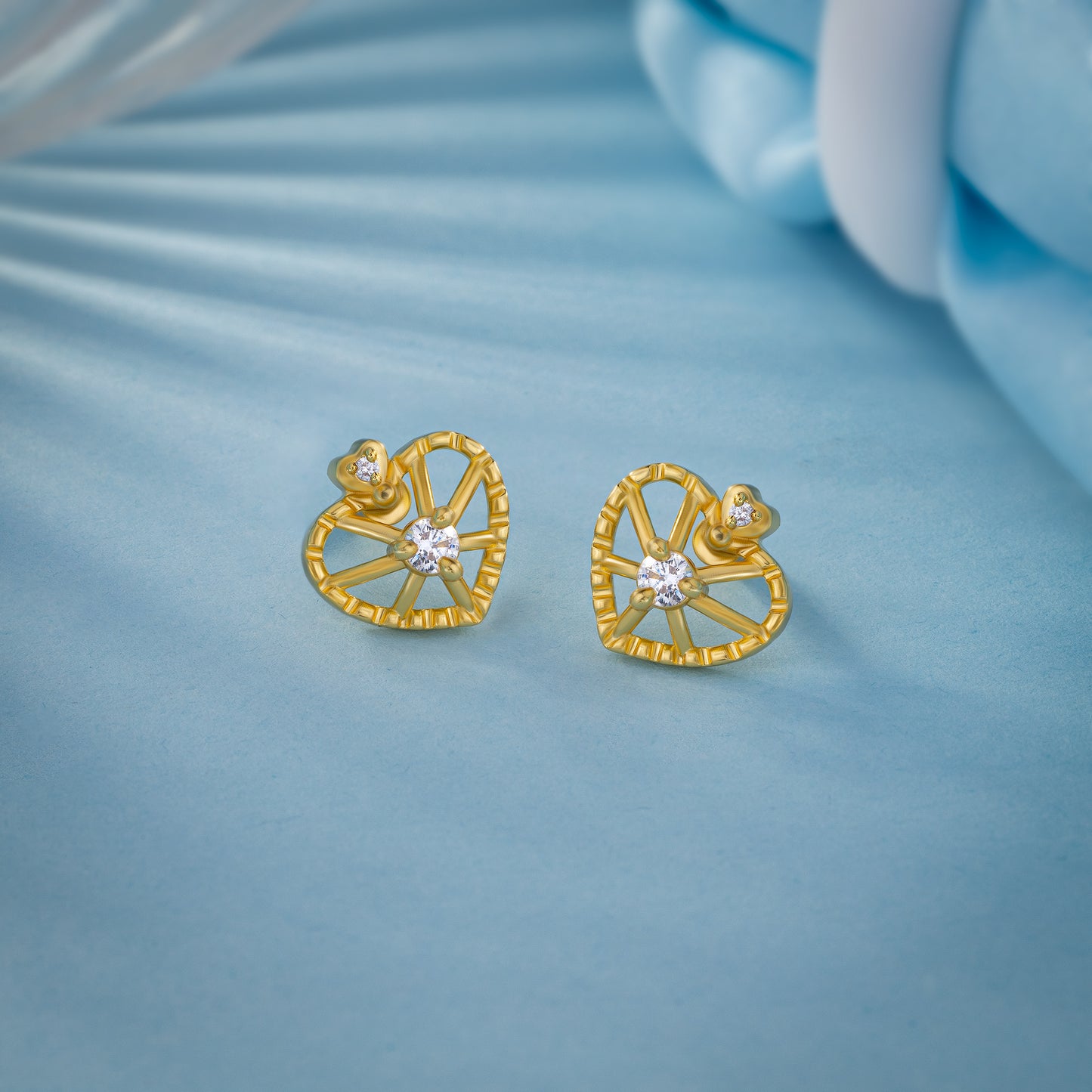 pair of golden earrings with a heart shaped diamond