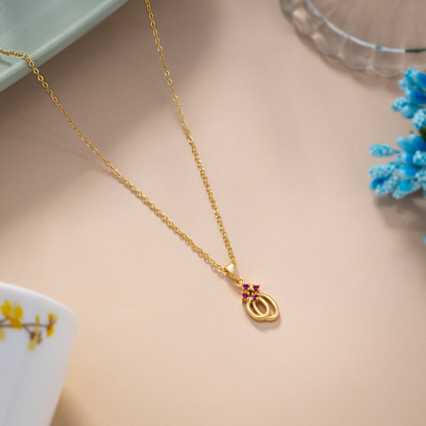 golden necklace with a red diamond pendant