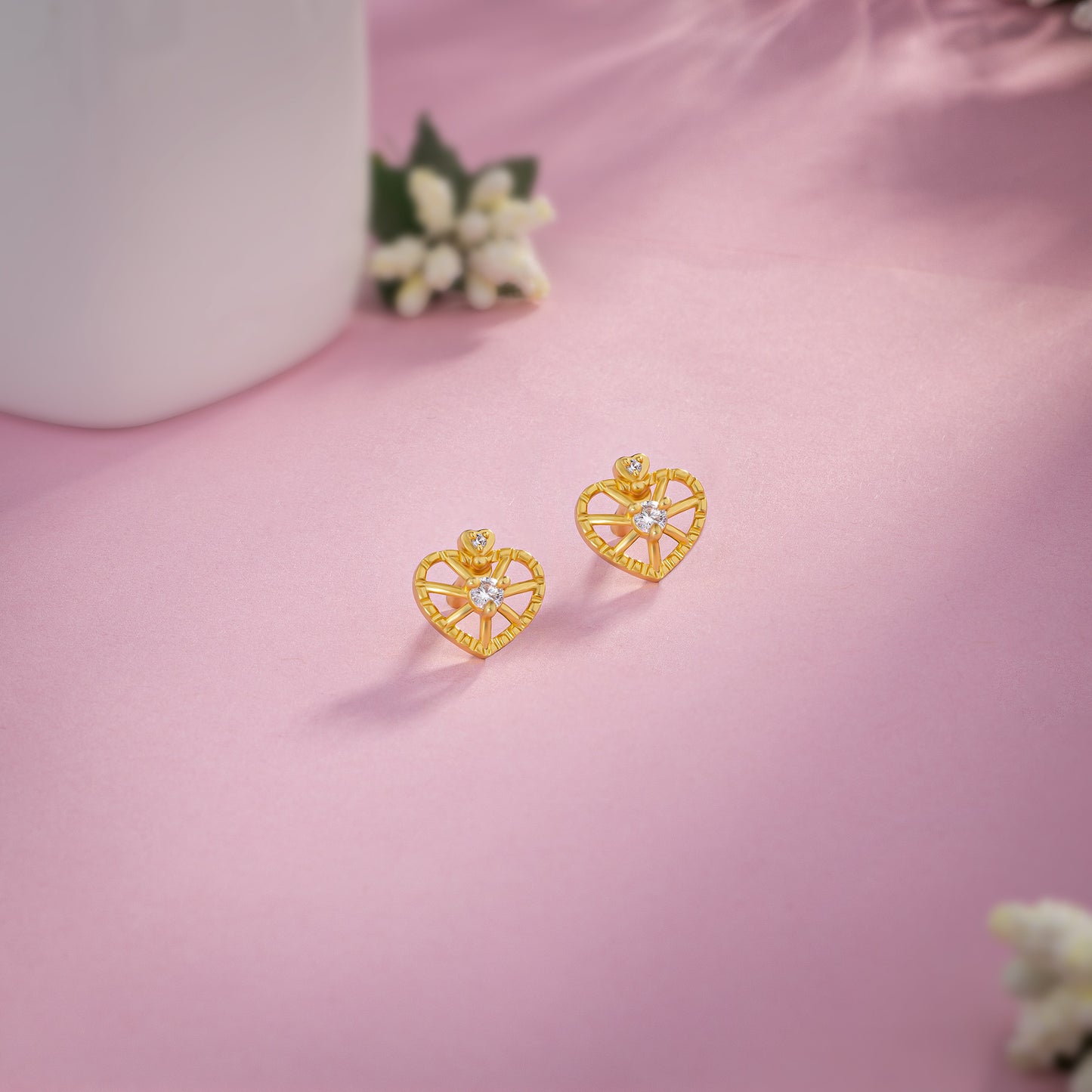 pair of golden earrings with a heart shaped diamond