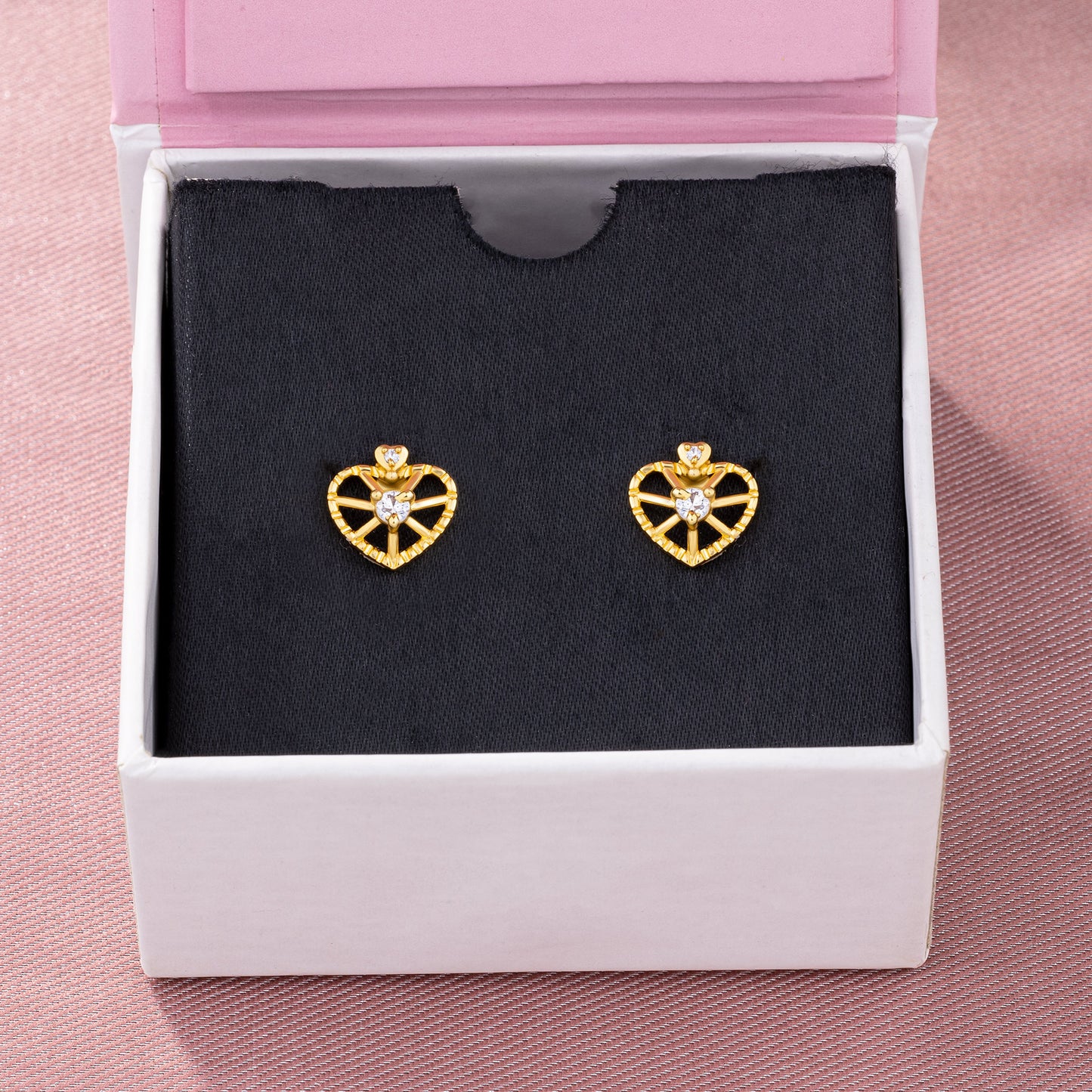 pair of golden earrings with a heart shaped diamond