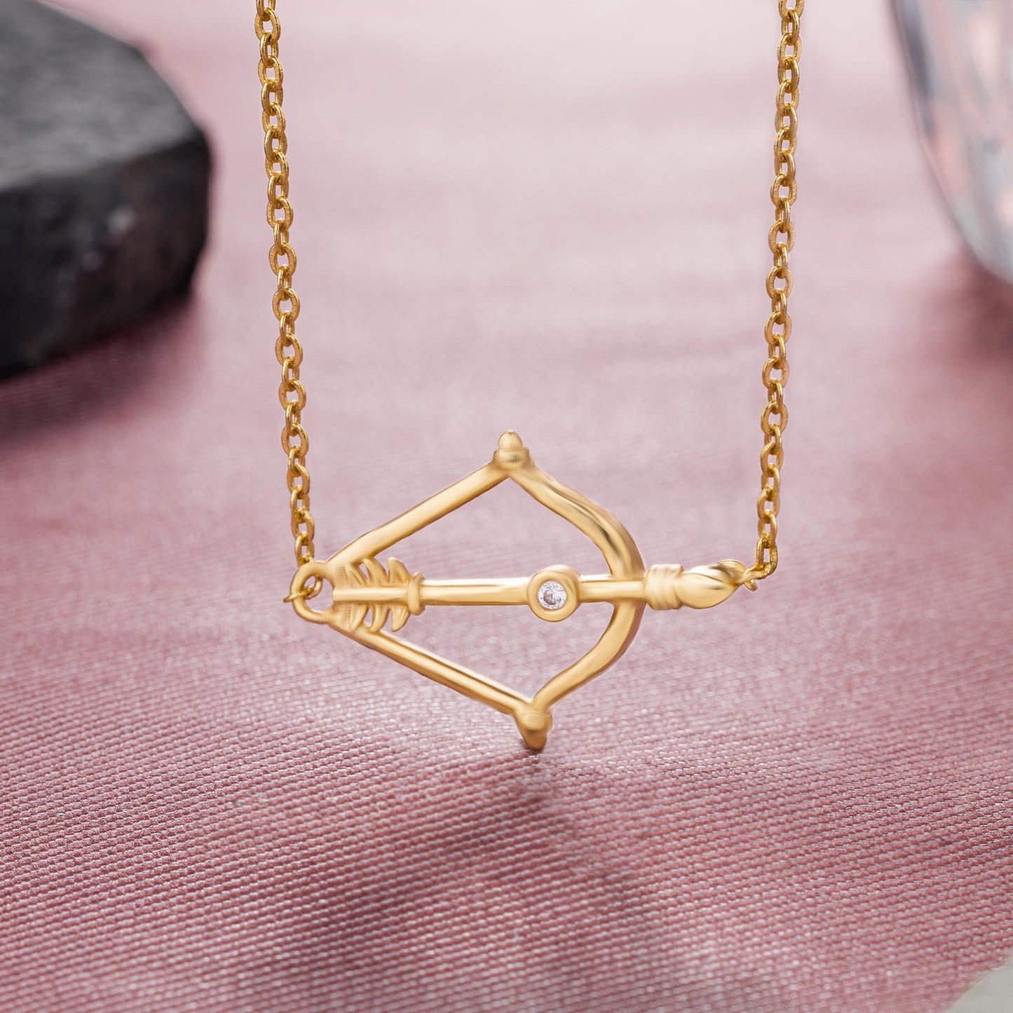 golden necklace with a small arrow on it