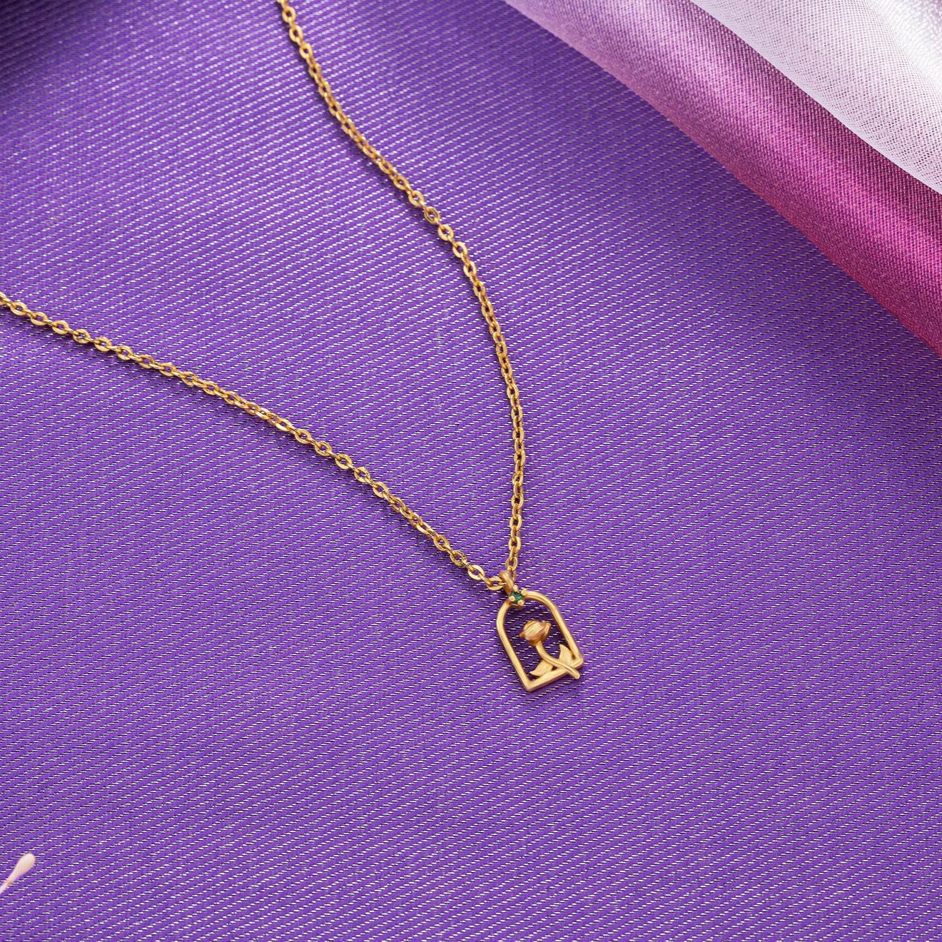 golden necklace with a small letter on it