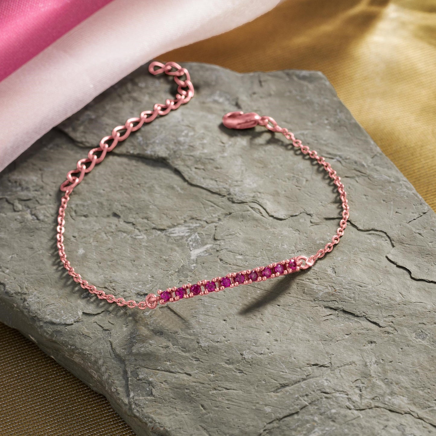 rose gold bracelet with a pink stone charm