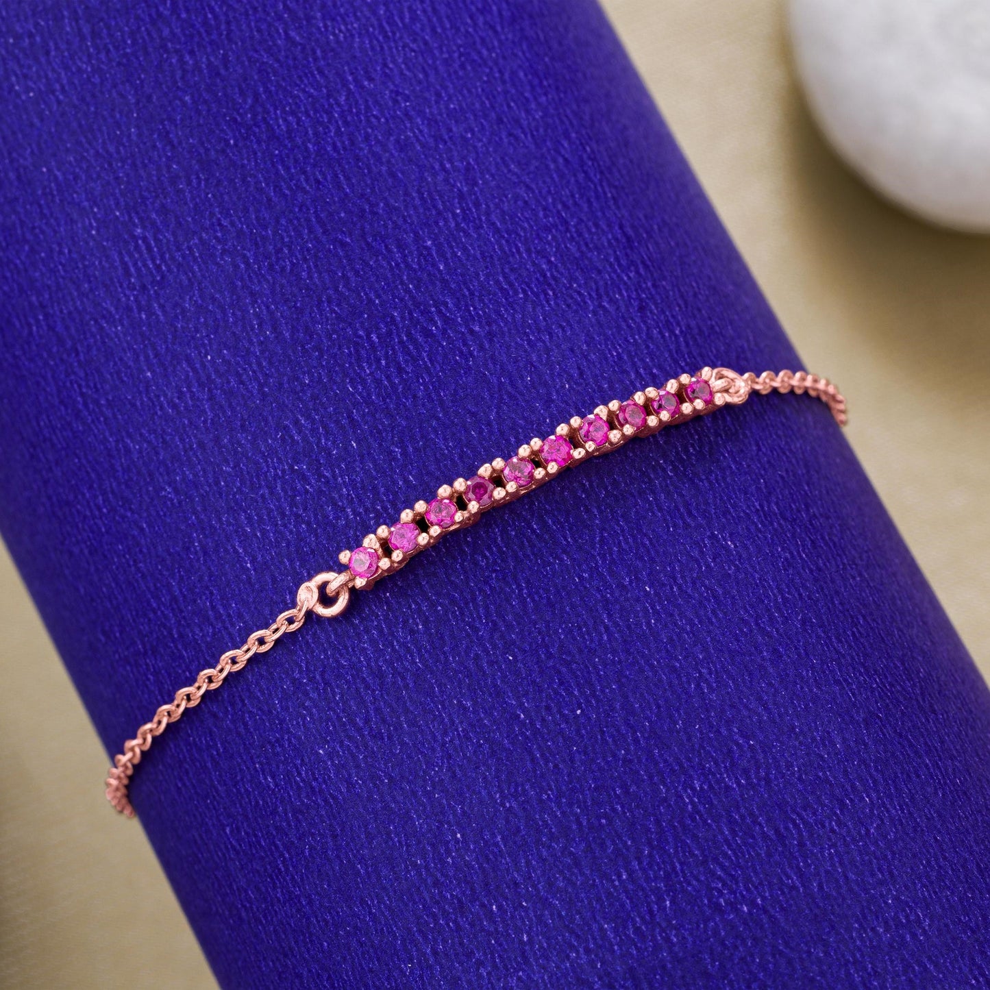 rose gold bracelet with a pink stone charm