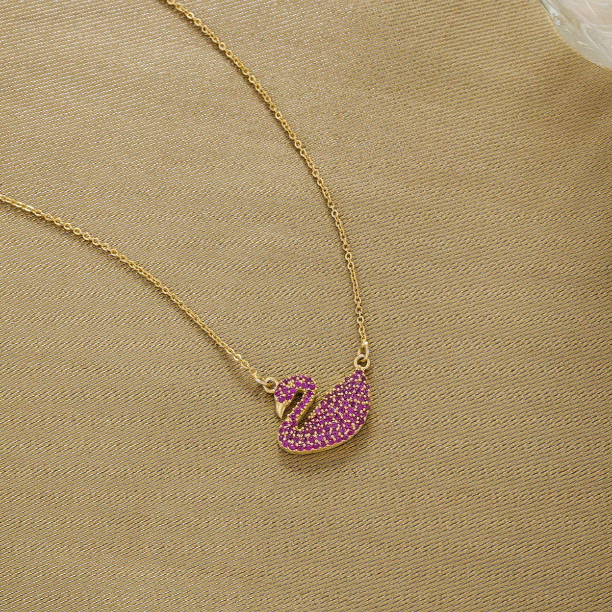 golden necklace with a stone swan