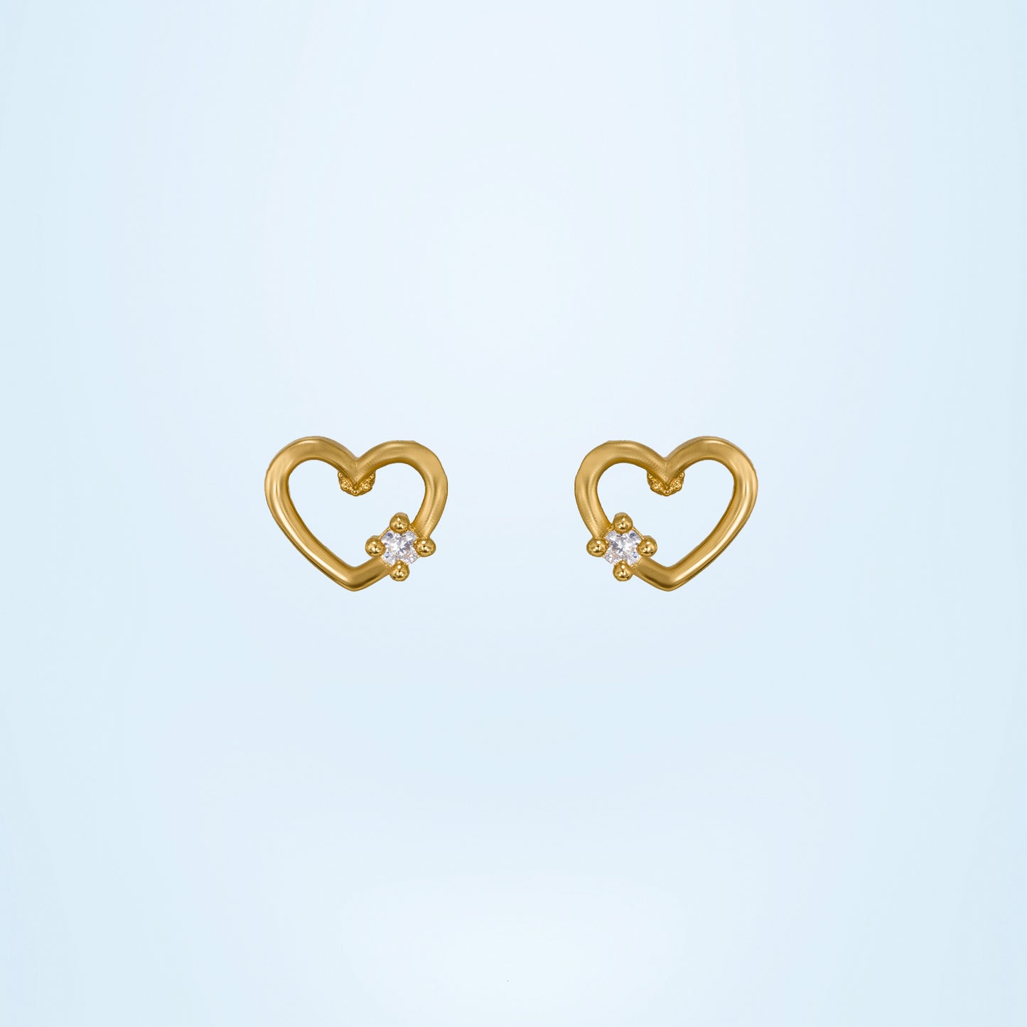 pair of golden earrings with a heart shaped diamond