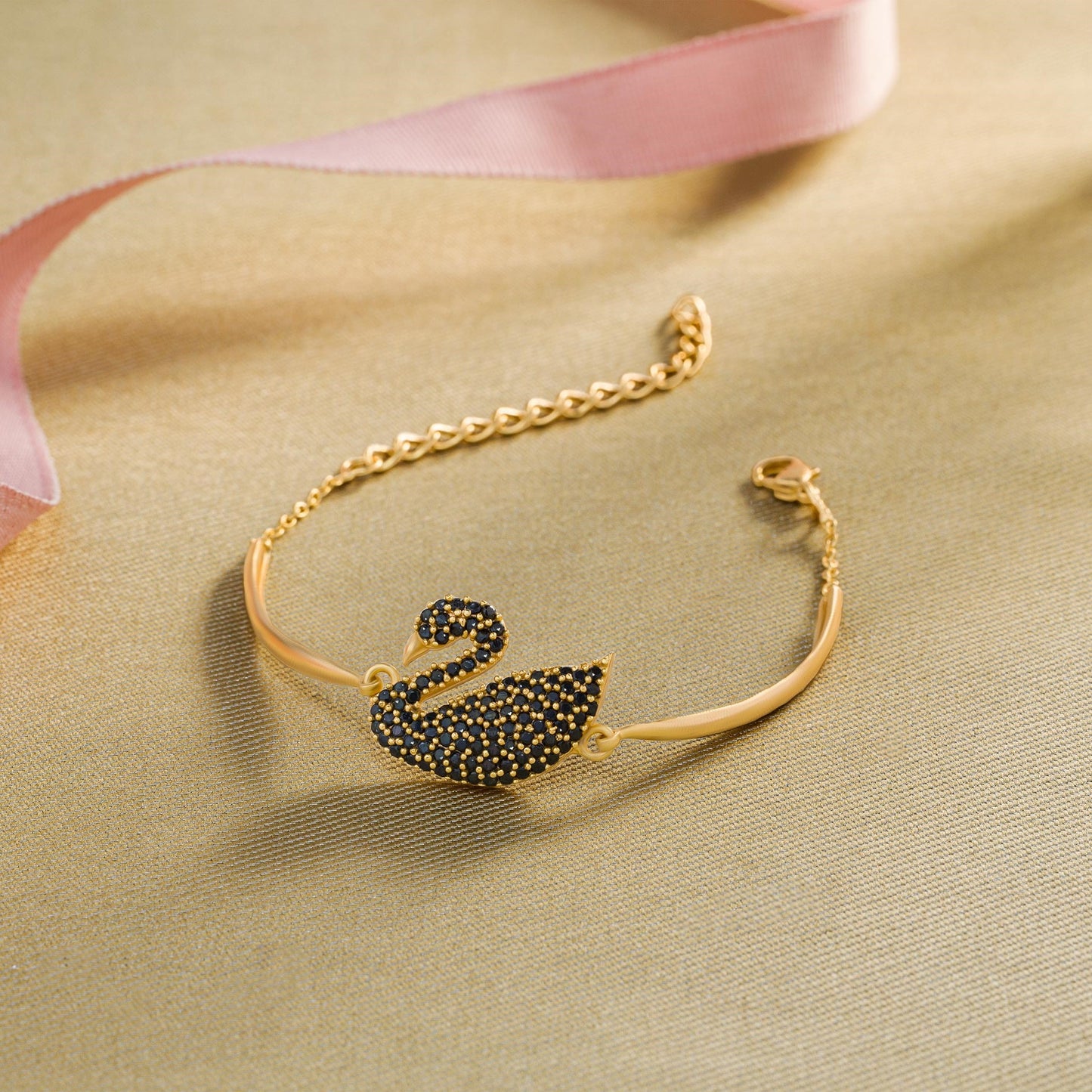 golden bracelet with a swan on it