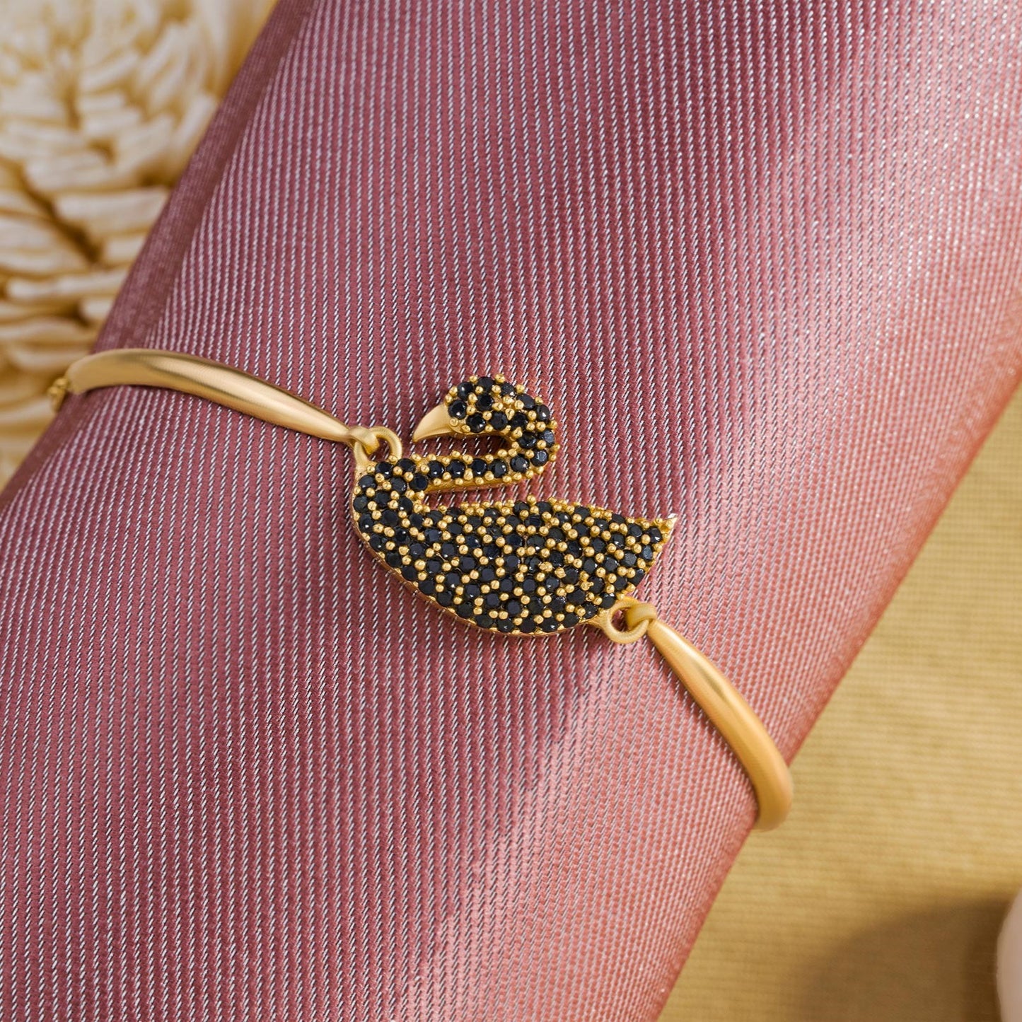 golden bracelet with a swan on it