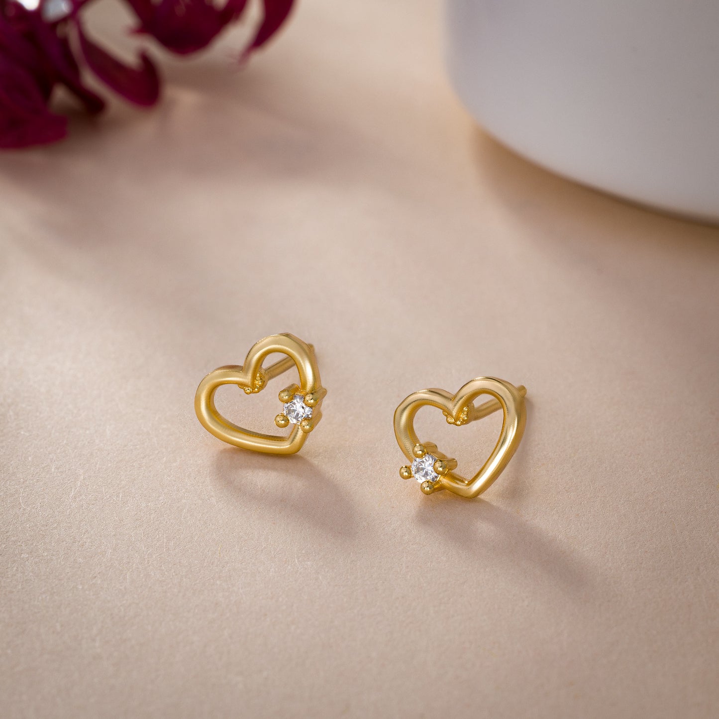 pair of golden earrings with a heart shaped diamond