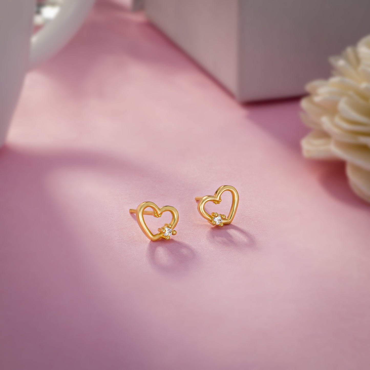 pair of golden earrings with a heart shaped diamond