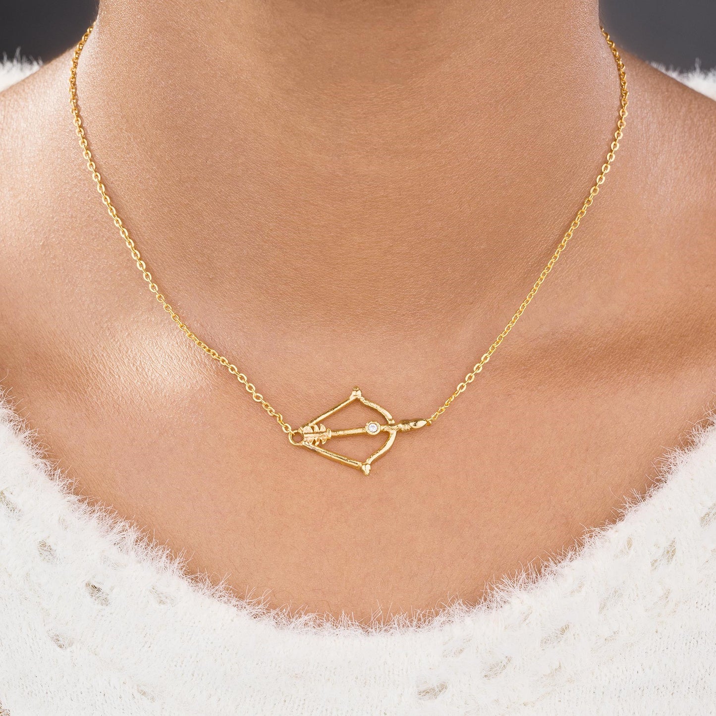 golden necklace with a small arrow on it