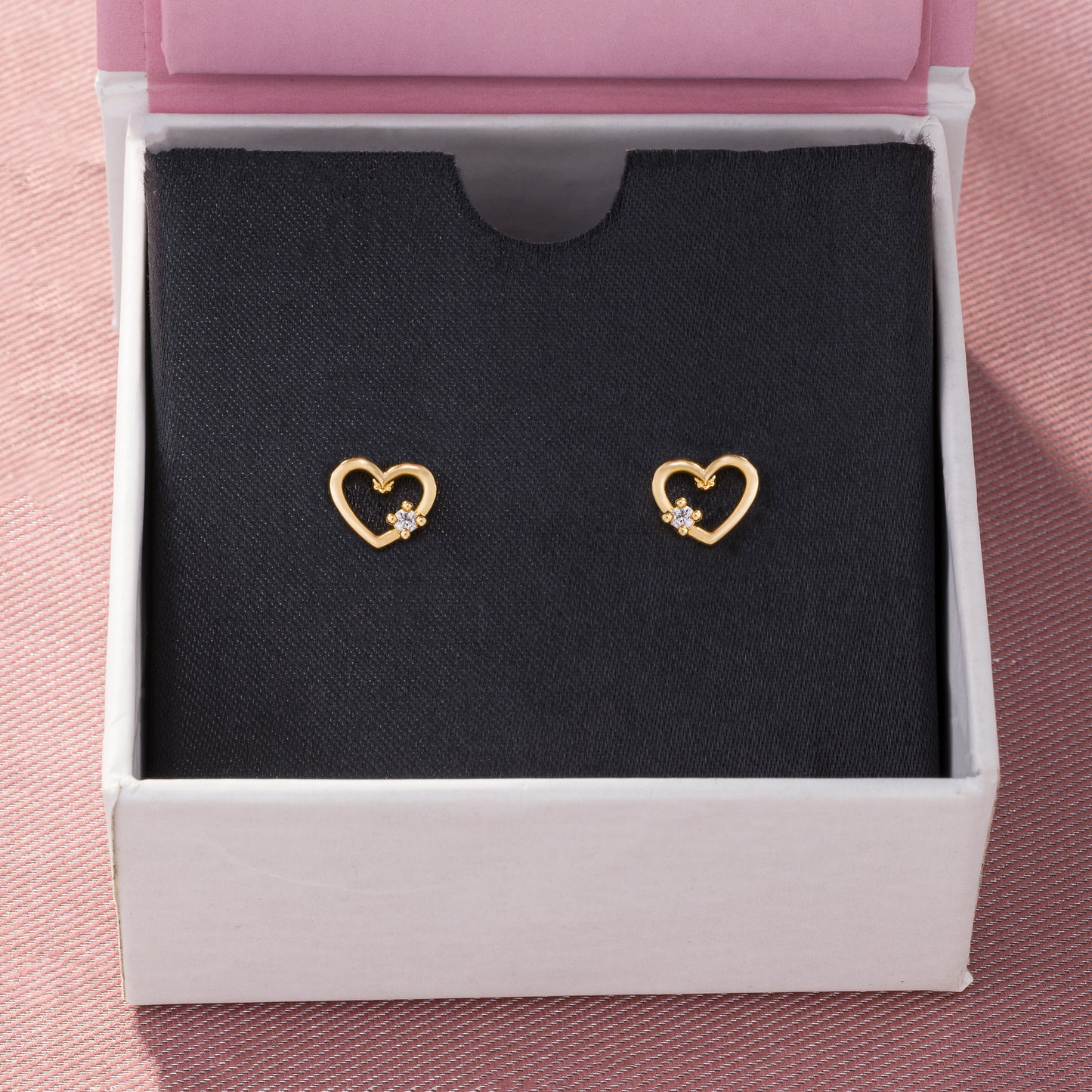 pair of golden earrings with a heart shaped diamond