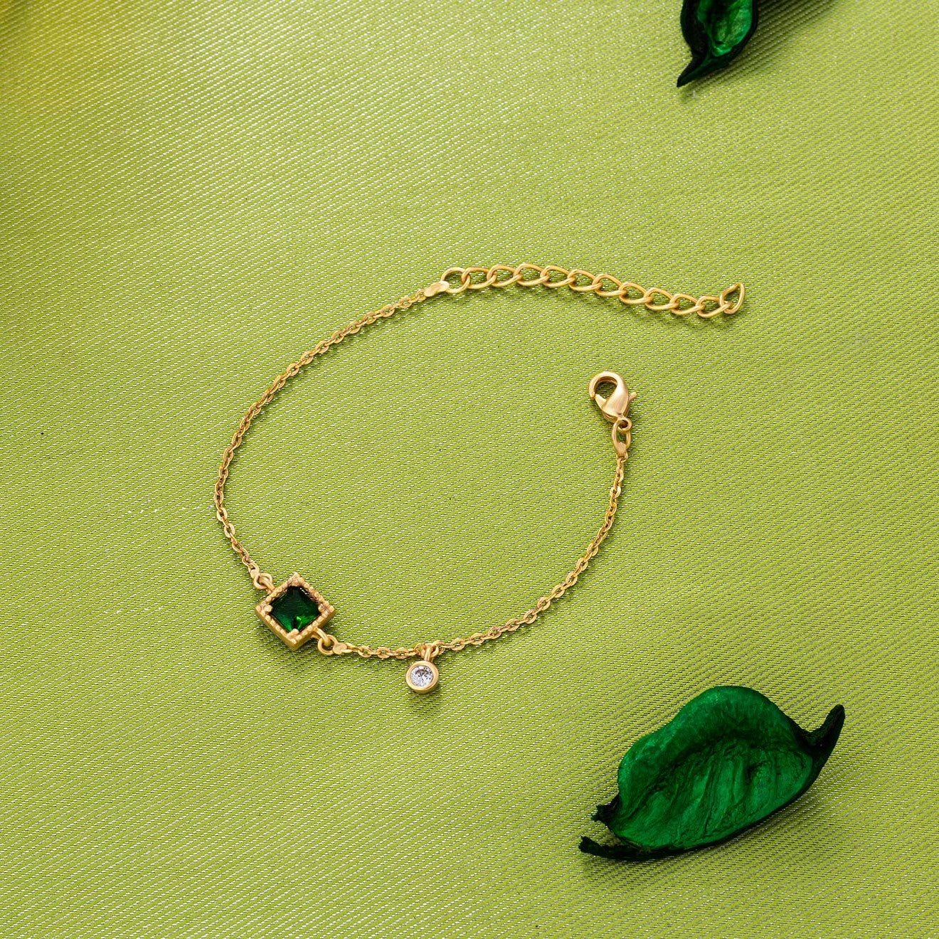 golden bracelet with a green stone