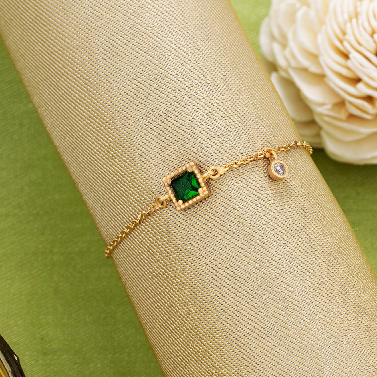 golden bracelet with a green stone