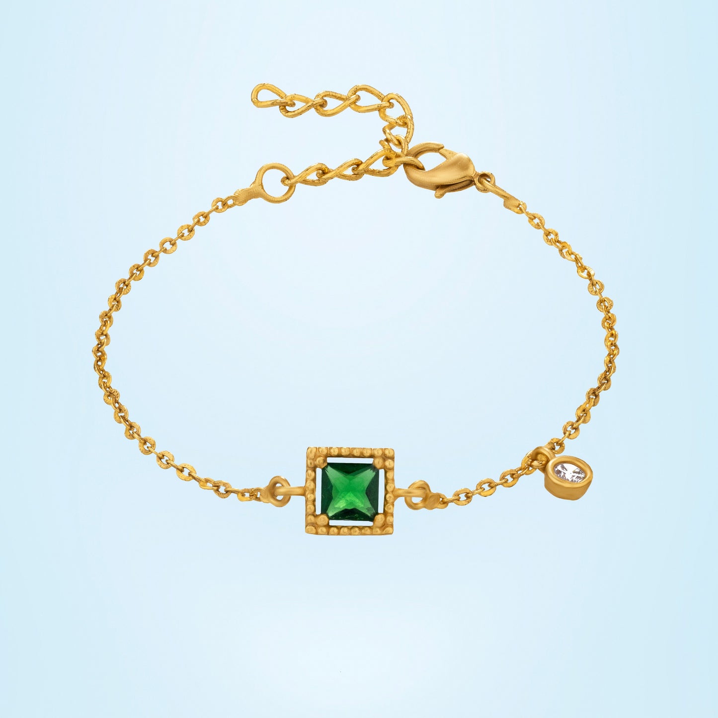 golden bracelet with a green stone