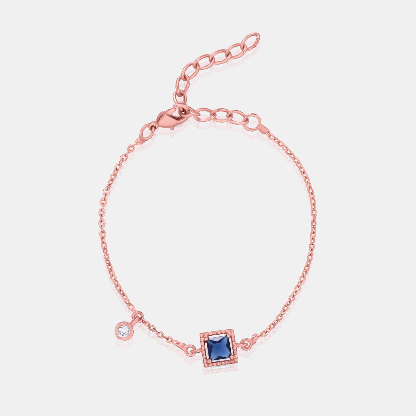 rose gold bracelet with a blue stone and hanging stud