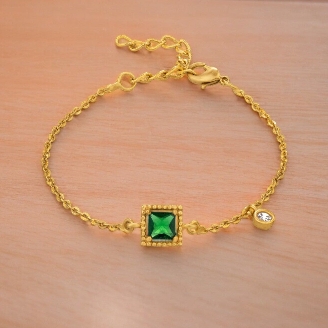 golden bracelet with a green stone