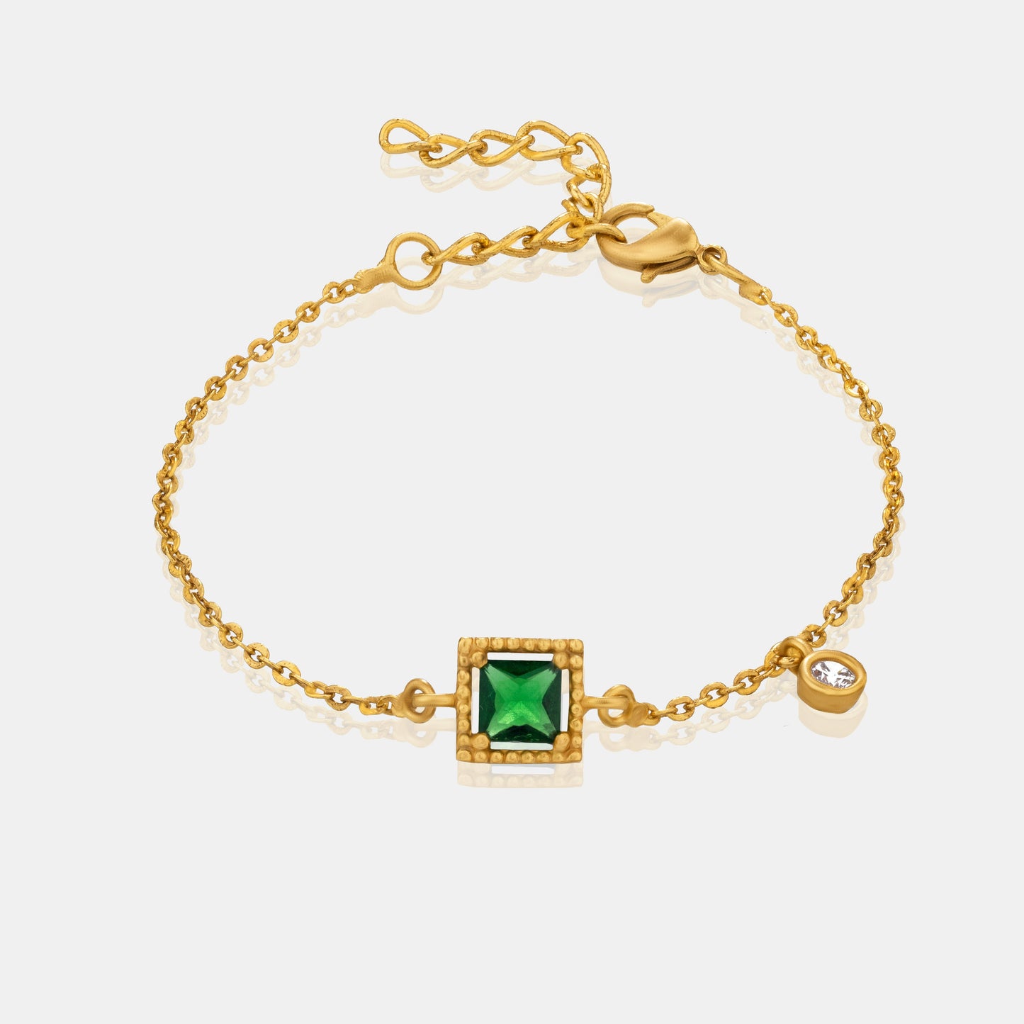 golden bracelet with a green stone