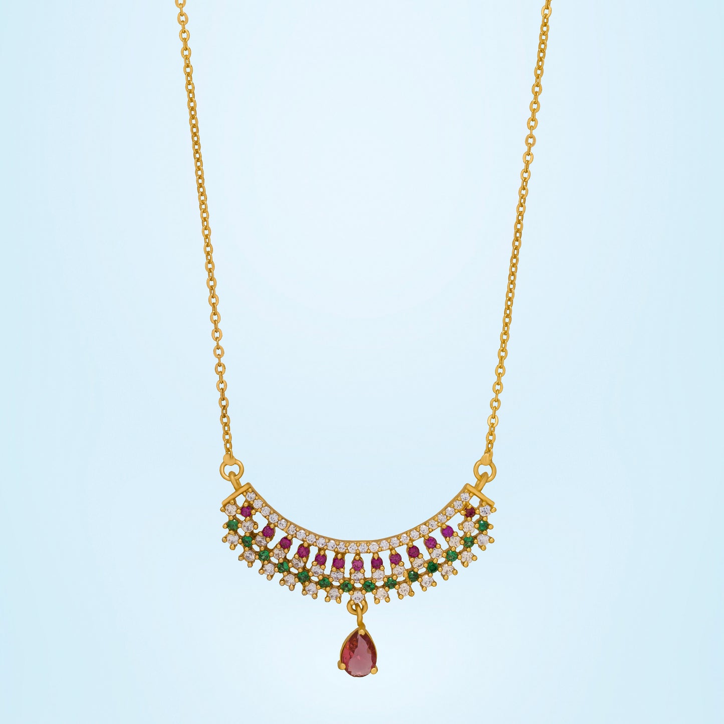 golden necklace with a ruby and emerald stone