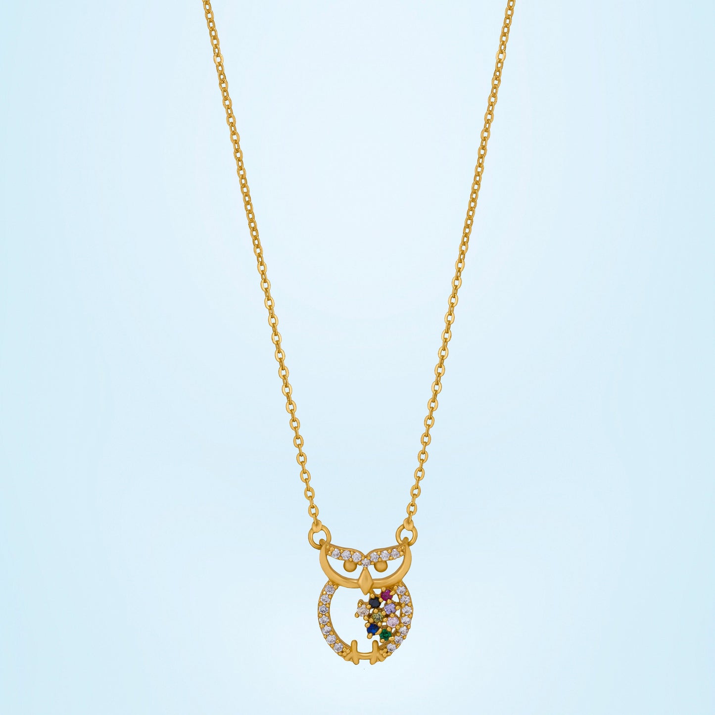 golden necklace with a diamond and emerald stone